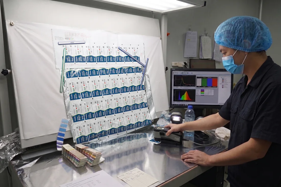 Operator reviewing printed artwork and color at a partner manufacturing facility