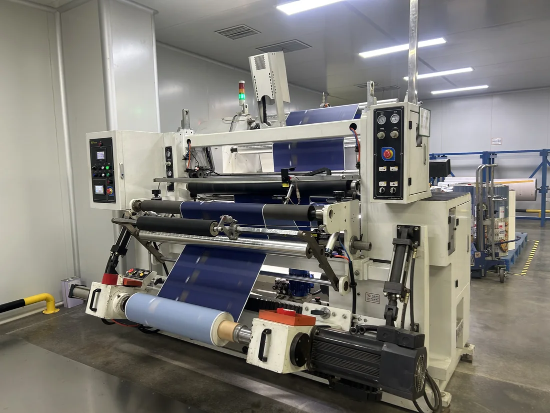 Printed film passing through inspection and rewinding equipment at a partner manufacturing facility