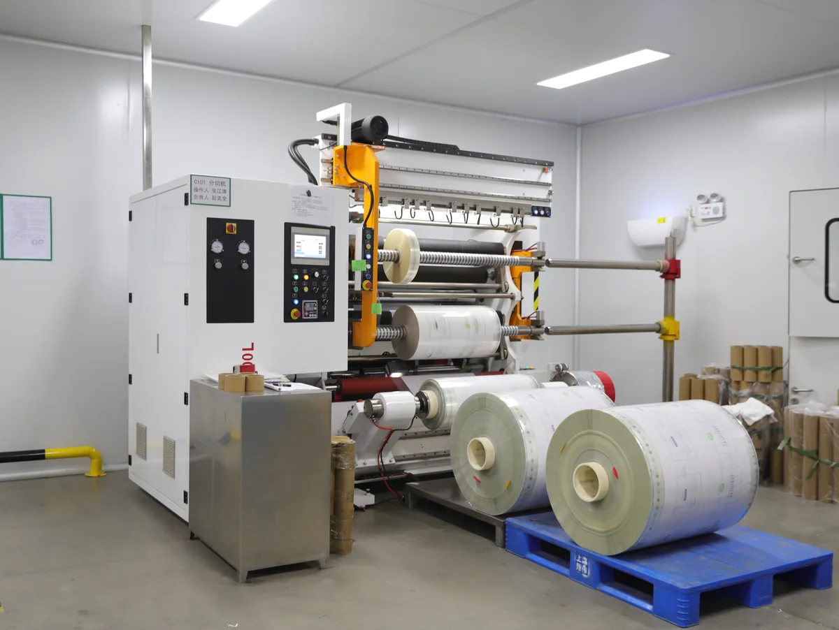 Slitting and rewinding machine with finished film rolls at a partner manufacturing facility